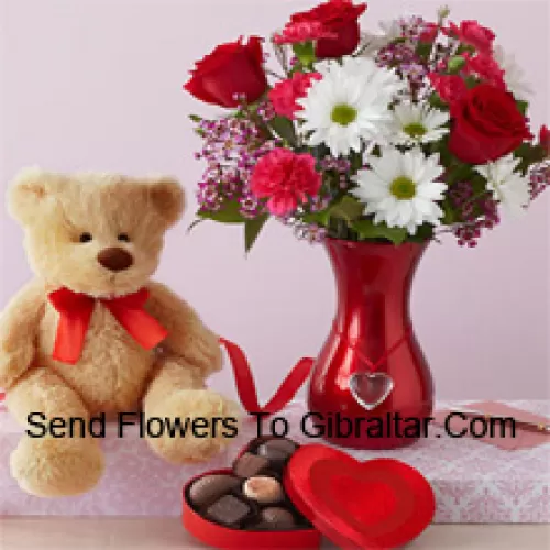 Rosas rojas y Gerberas blancas con algunos helechos en un jarrón de vidrio junto con un lindo oso de peluche marrón de 12 pulgadas de altura y una caja de chocolates importados